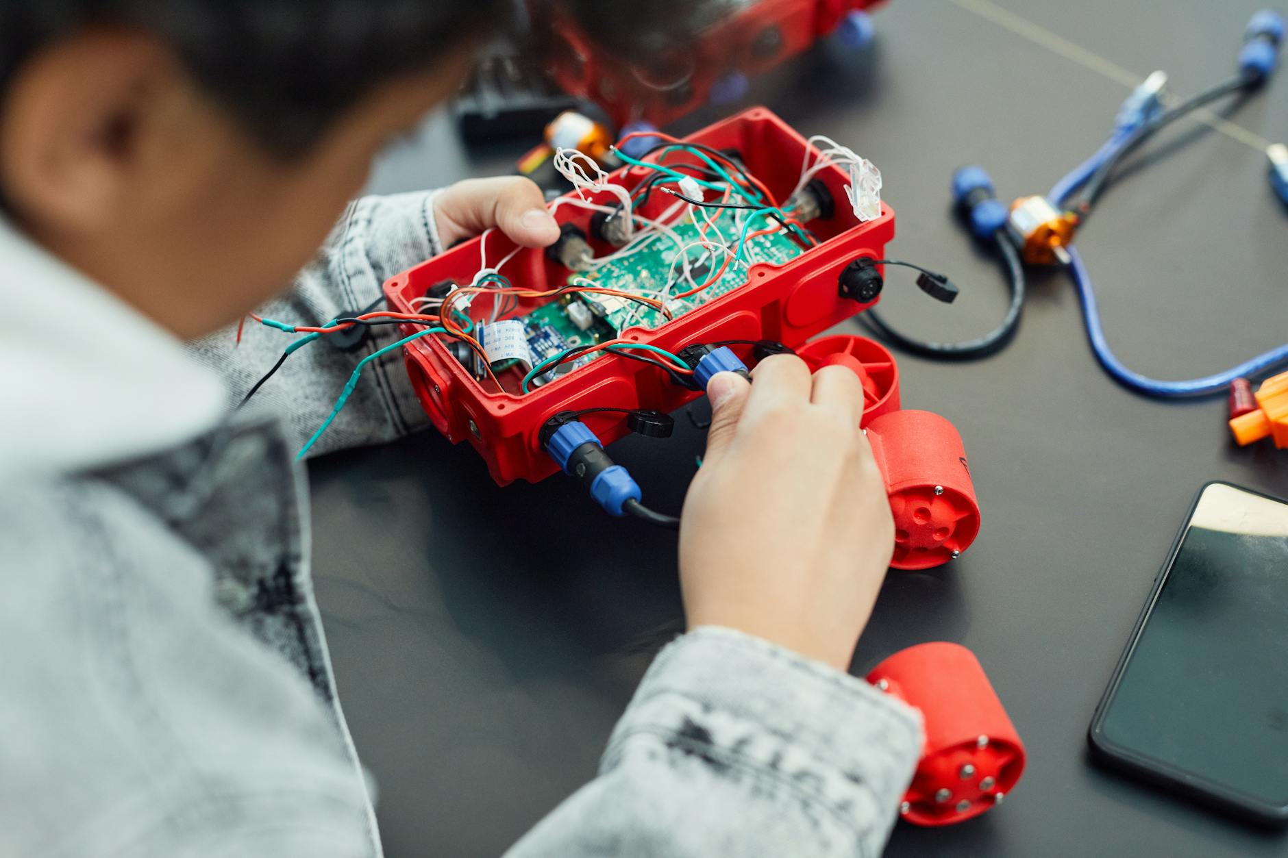Dziecko składa projekt robota z elektronicznych podzespołów