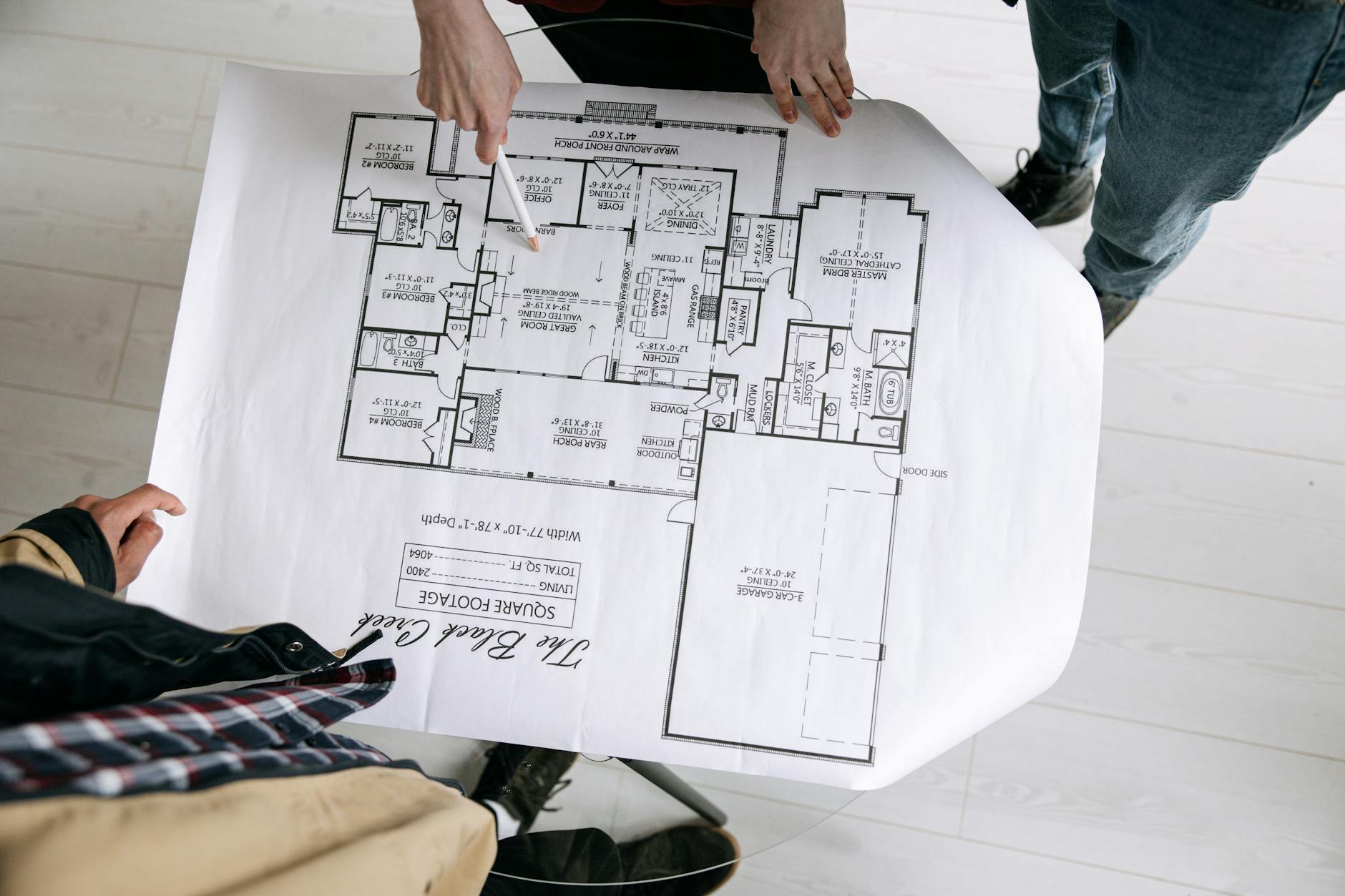 Architekci analizują szczegółowy rzut małego domu na stole