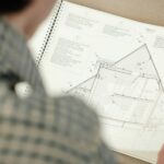 Osoba analizująca szczegółowy plan architektoniczny domu