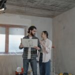 Para omawia plan domu w niewykończonym pomieszczeniu