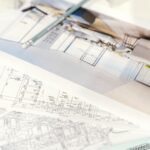 Zbliżenie projektu 3D i planów technicznych domu modułowego na biurku
