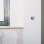 Montaż nowego gniazdka elektrycznego w jasnym mieszkaniu przy oknie
