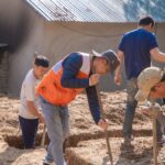 Pracownicy kopią wykopy fundamentowe na placu budowy
