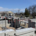 Pracownicy na nasłonecznionej płycie fundamentowej na placu budowy